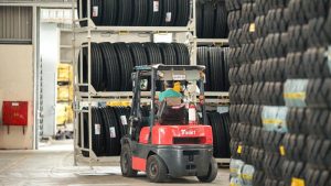 Hình ảnh công nhân đang lái xe nâng sắp xếp lốp lên kệ